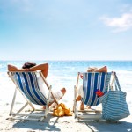 Couple on a deck chair relaxing on the beach