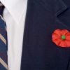 A close up of a man wearing a poppy for Poppy Day